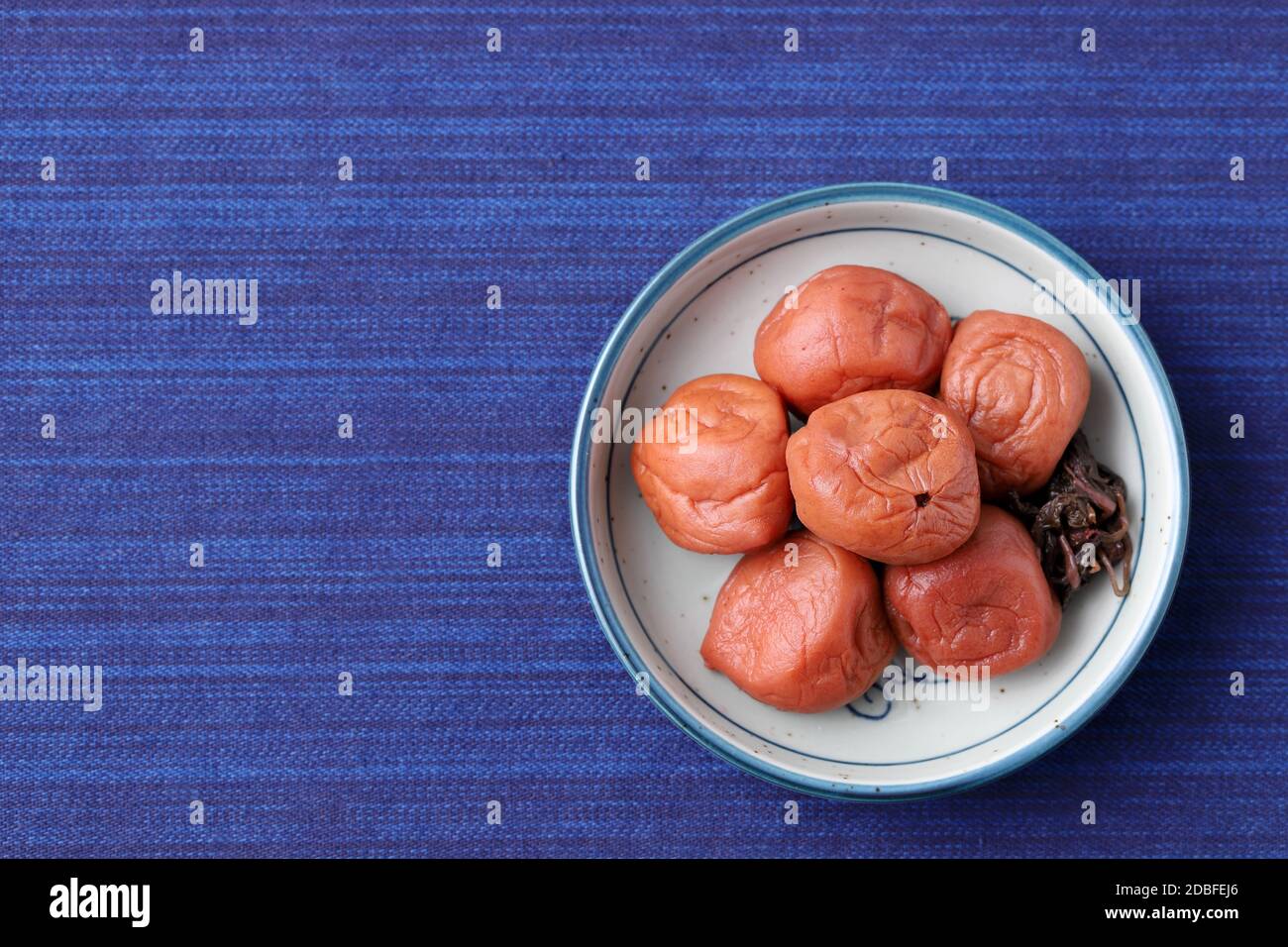 Japanese food, pickled Umeboshi in a dish on table, top view Stock Photo