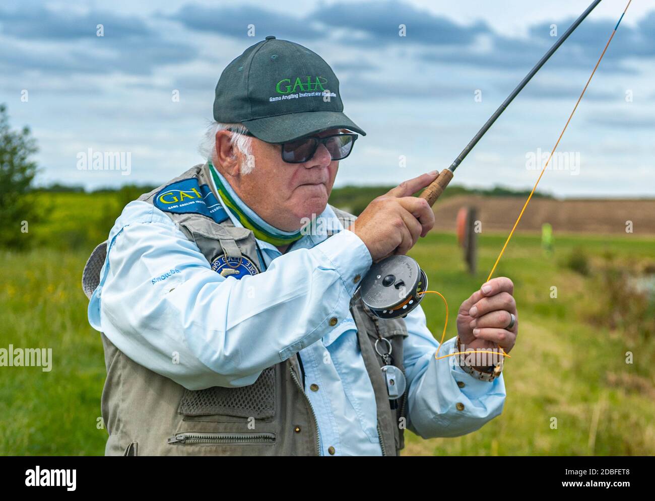 Lincolnshire, UK - Mr Barry Grantham, an instructor in fly fishing, casting a fly line across a trout lake for rainbow trout Stock Photo