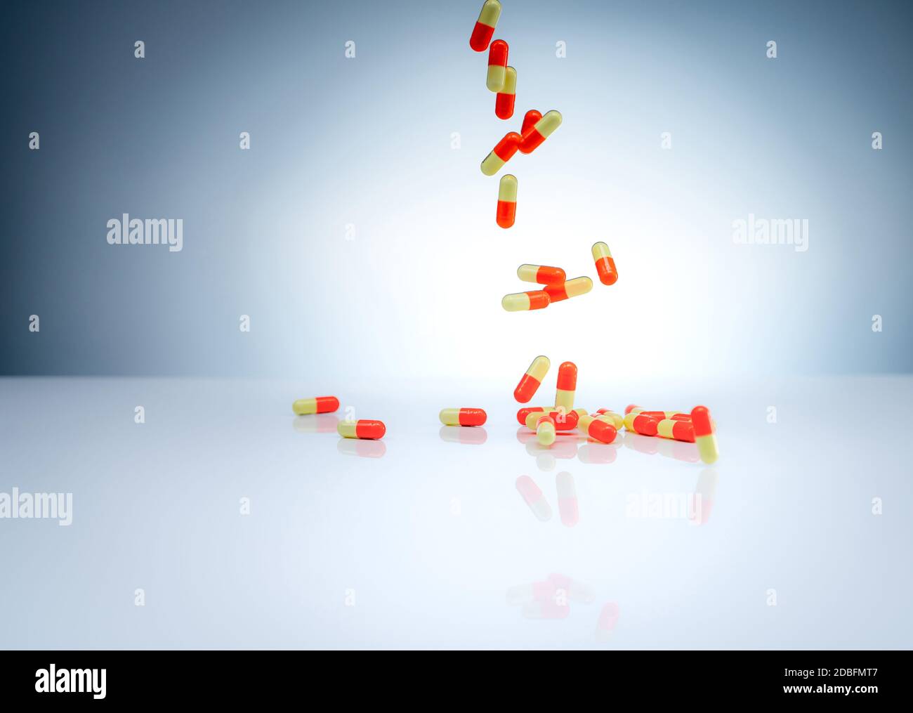 Yelloworange capsules pill falling down on white table. Pharmaceutical