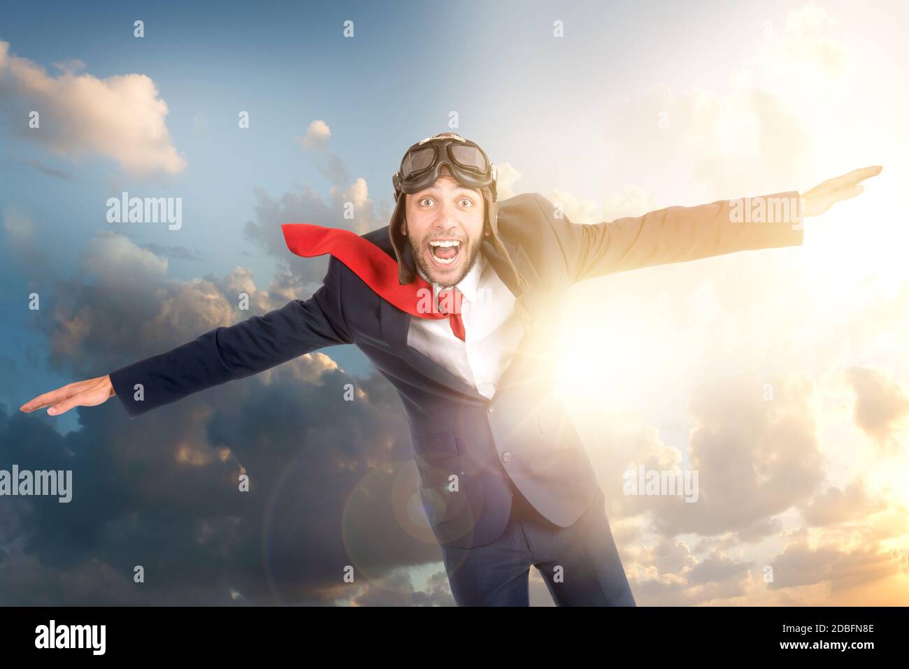 Businessman with pilot goggles flying in the sky Stock Photo