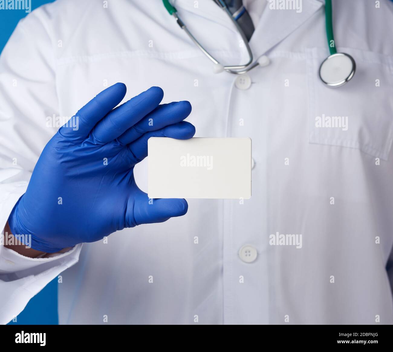 doctor therapist is dressed in a white robe uniform and blue sterile ...