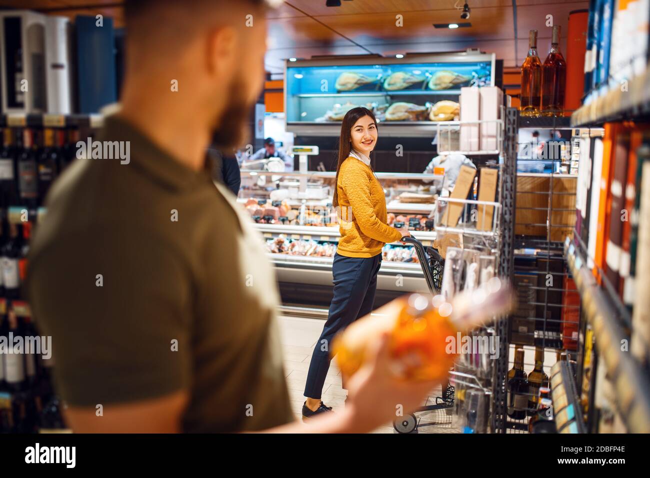 Family couple in grocery store, alcohol department. Man and woman with