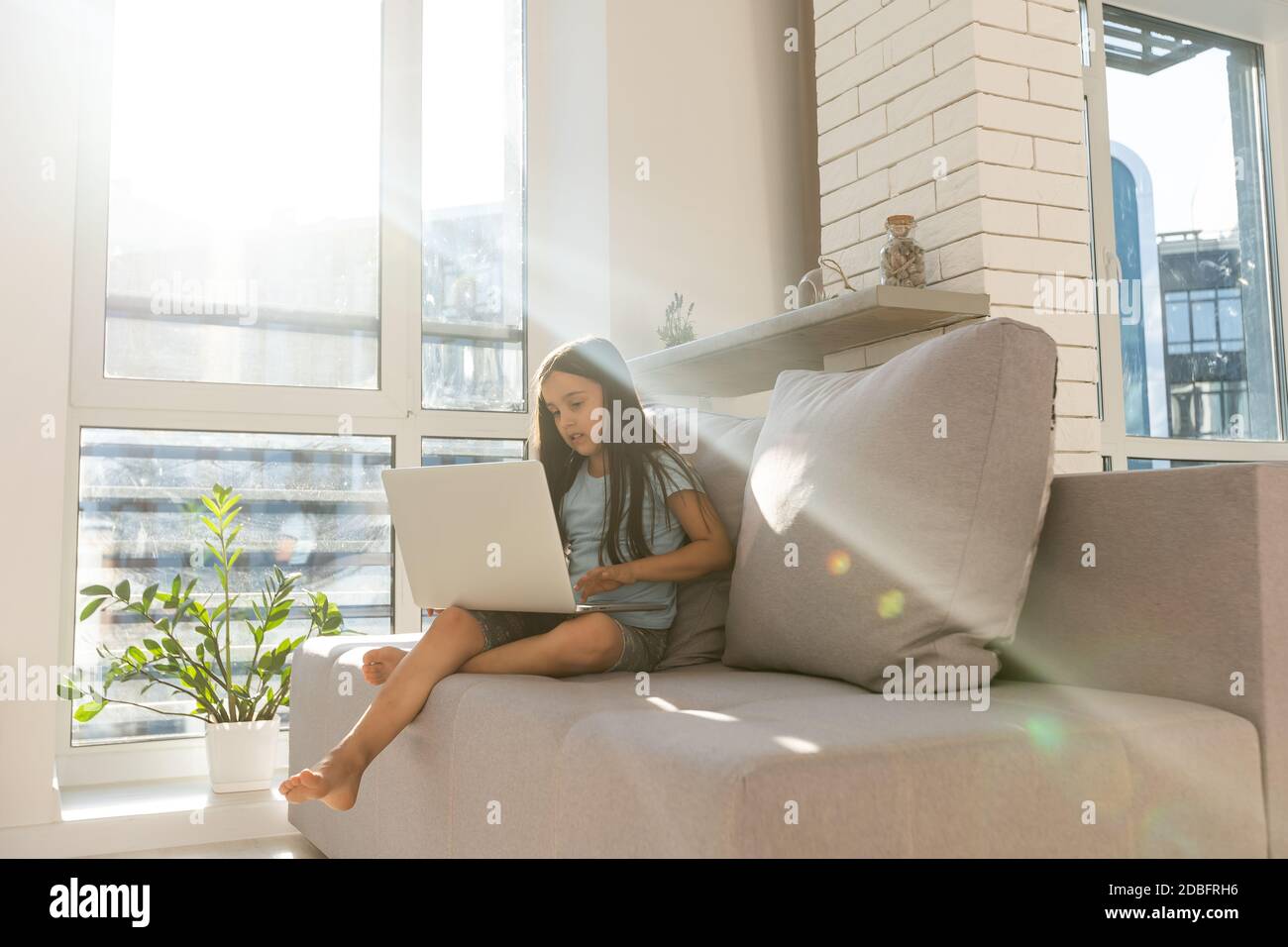 Little girl studying online using her laptop at home Stock Photo - Alamy