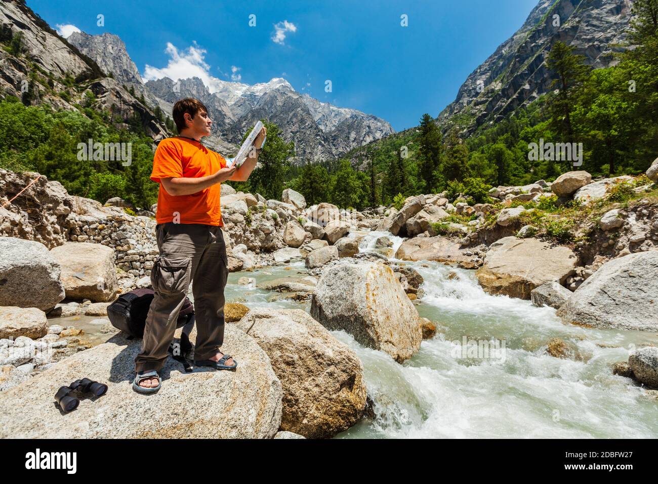 Hiker trekker studying map route on trek in Himalayas mountains. Himachal Pradesh,India Stock Photo