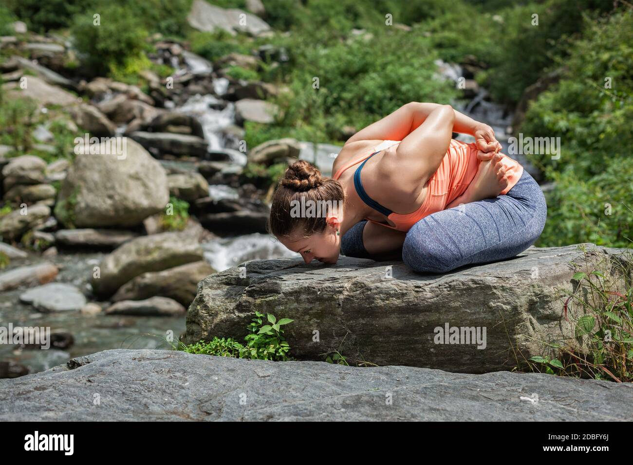 Young sporty fit woman doing yoga meditating in Baddha Padmasana
