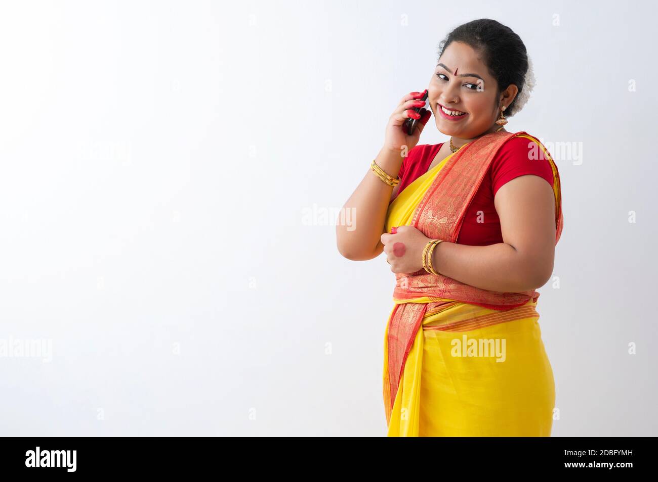 Woman in saree smiling while talking on the phone happily Stock Photo