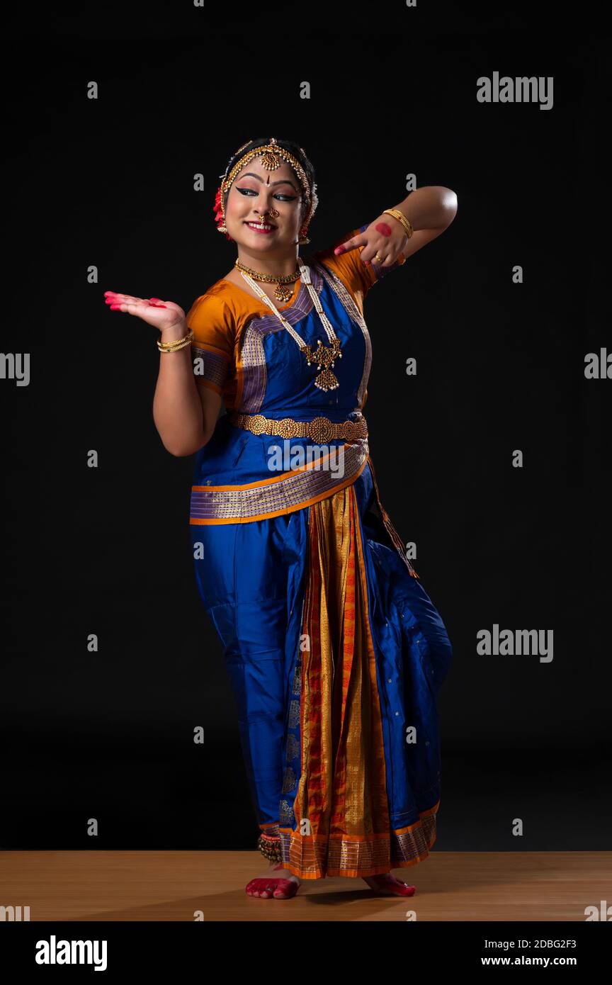 Kuchipudi dancer pointing towards her palm with a smile on her face Stock Photo