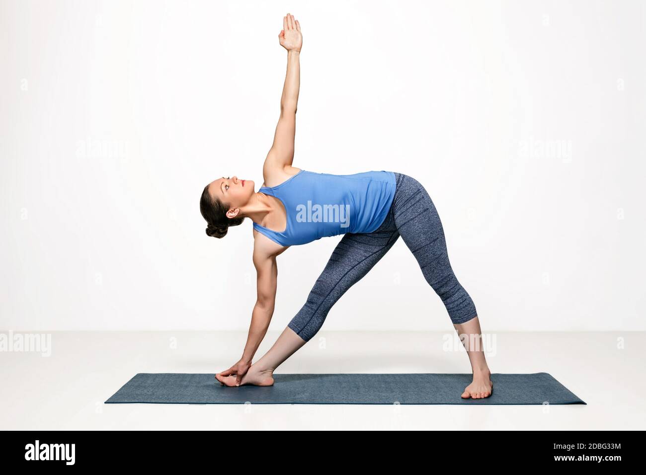 Beautiful sporty fit woman practices Ashtanga Vinyasa yoga asana utthita trikonasana - extended triangle pose Stock Photo