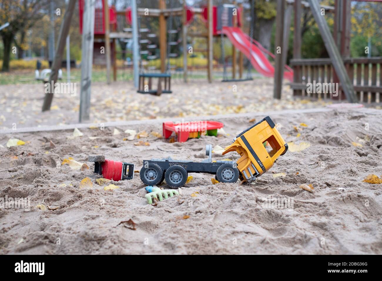 Deserted playground in a city park with broken kids toys during COVID-19 lockdown. Corona virus social distancing restrictions. Empty park. Stock Photo