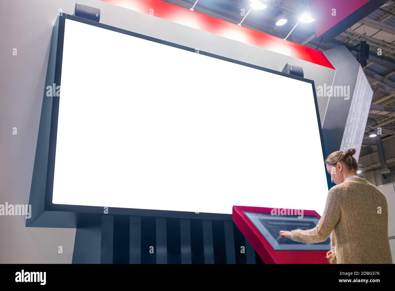 Mockup image - woman looking at white empty large wall display Stock Photo