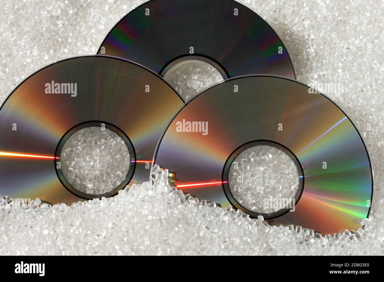 Three DVD disks with plastic granulate material Stock Photo