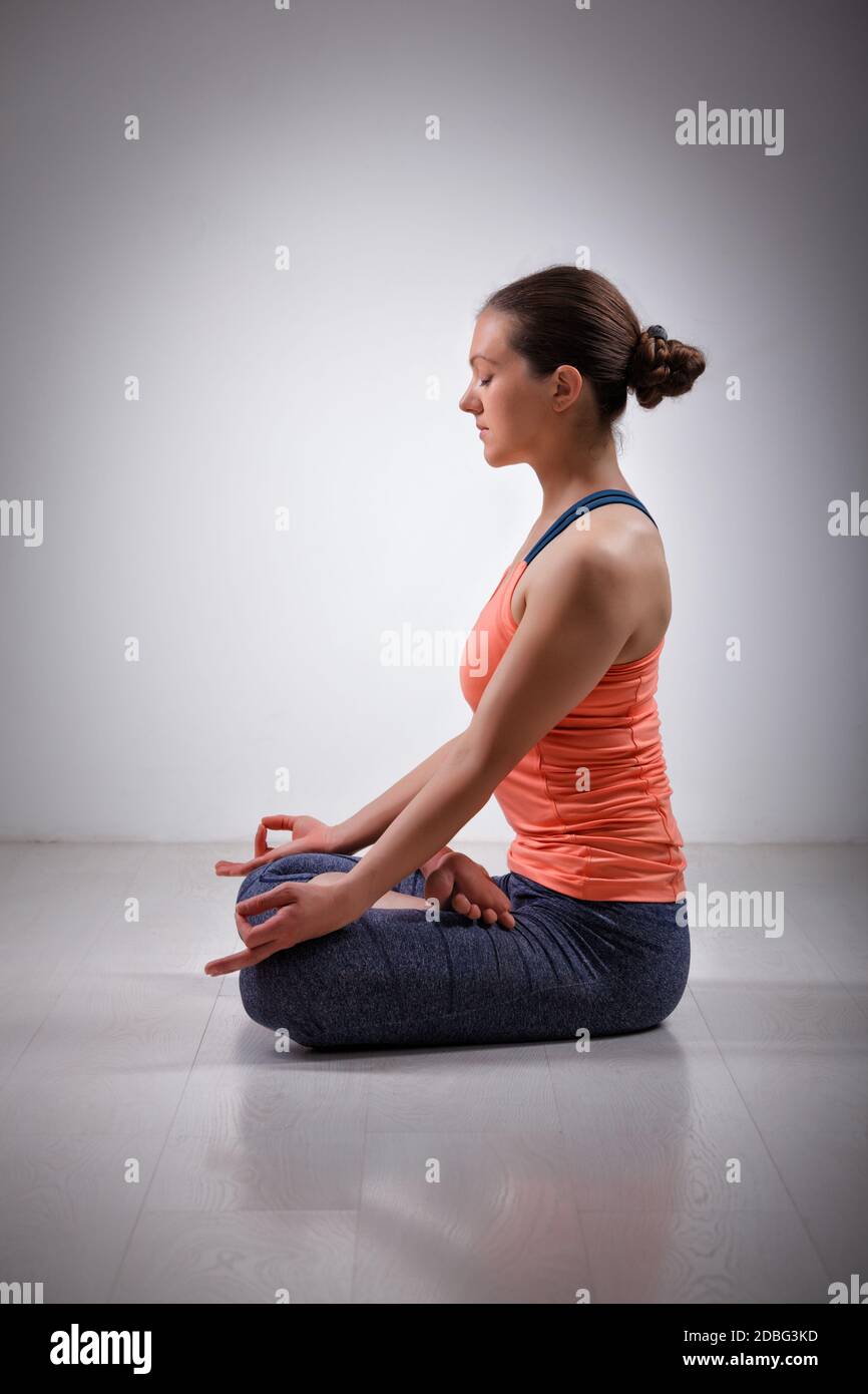 Beautiful fit yogini woman meditating in yoga asana Padmasana (Lotus
