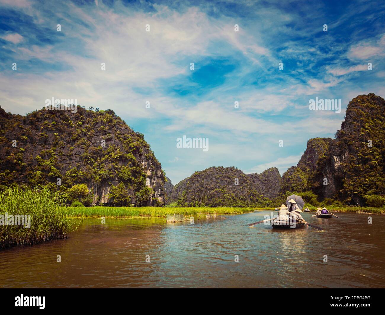 Vintage retro effect filtered hipster style image of tourists on boats in Tam Coc-Bich Dong Ngo Dong river in popular tourist destination near Ninh Bi Stock Photo