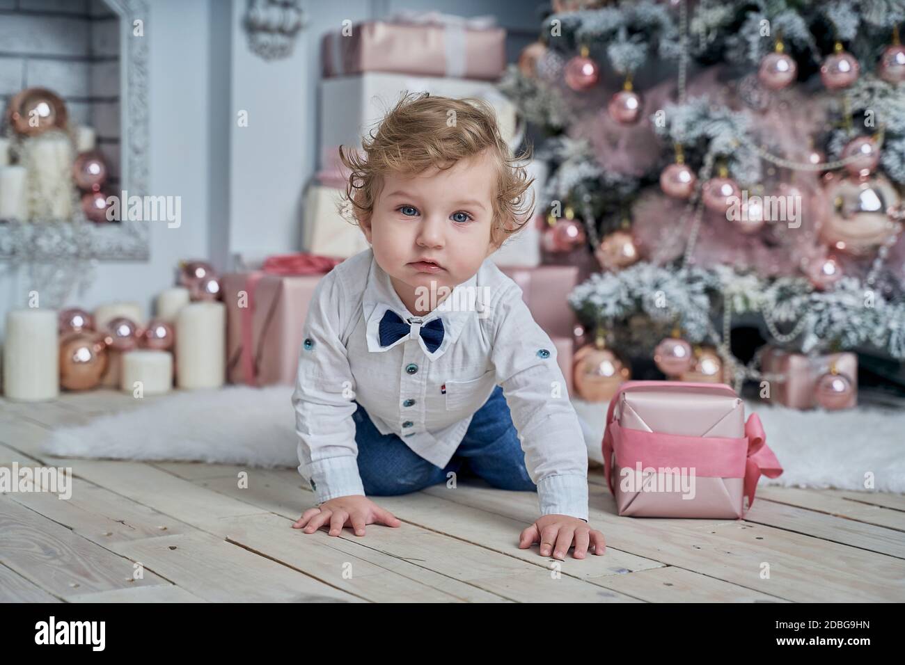 Little funny baby next to the Christmas tree Stock Photo