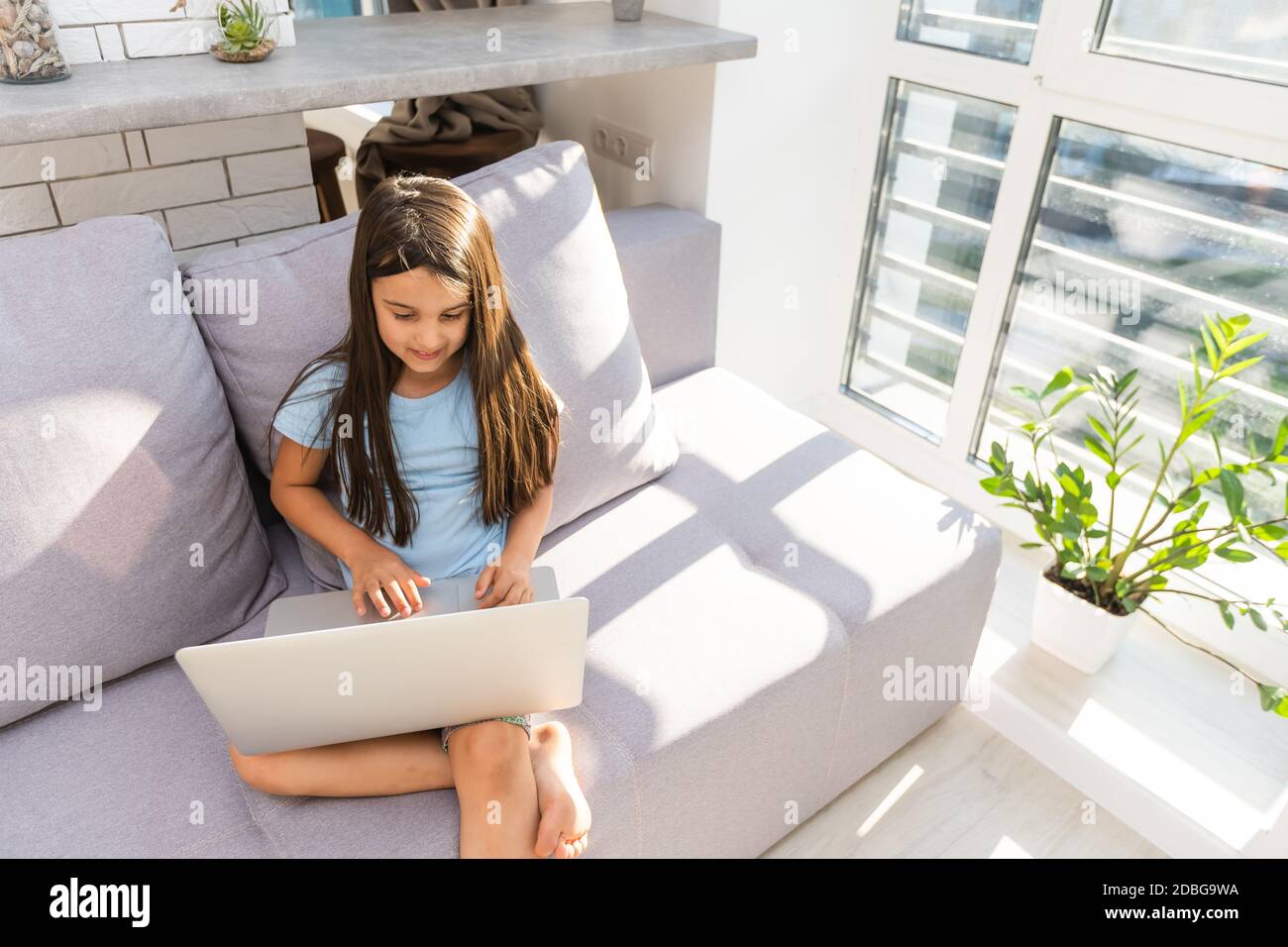 Little girl studying online using her laptop at home Stock Photo - Alamy