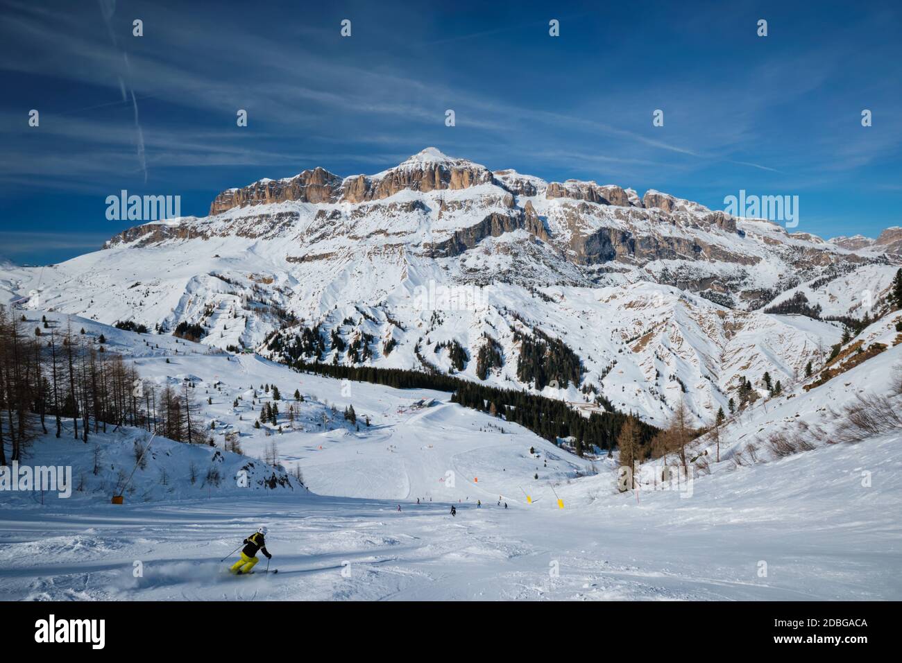 View of a ski resort piste with people skiing in Dolomites in Italy. Ski area Arabba. Arabba, Italy Stock Photo