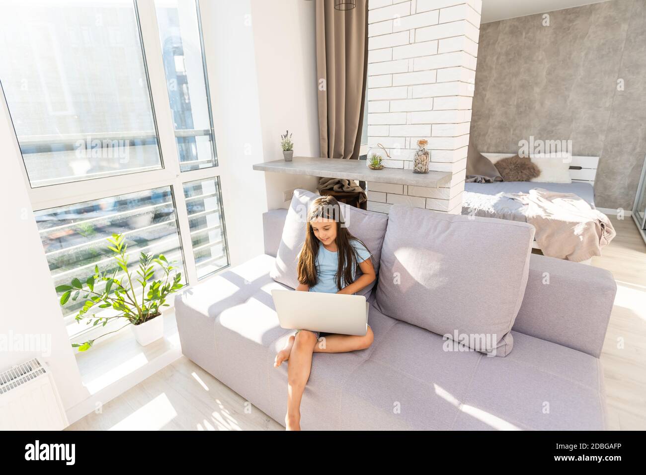 Little girl studying online using her laptop at home Stock Photo - Alamy