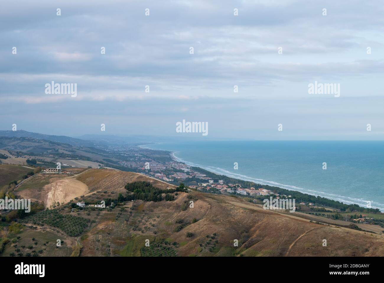 Wide angle shot of city against beach, sea and sky with horizon and mountains Stock Photo