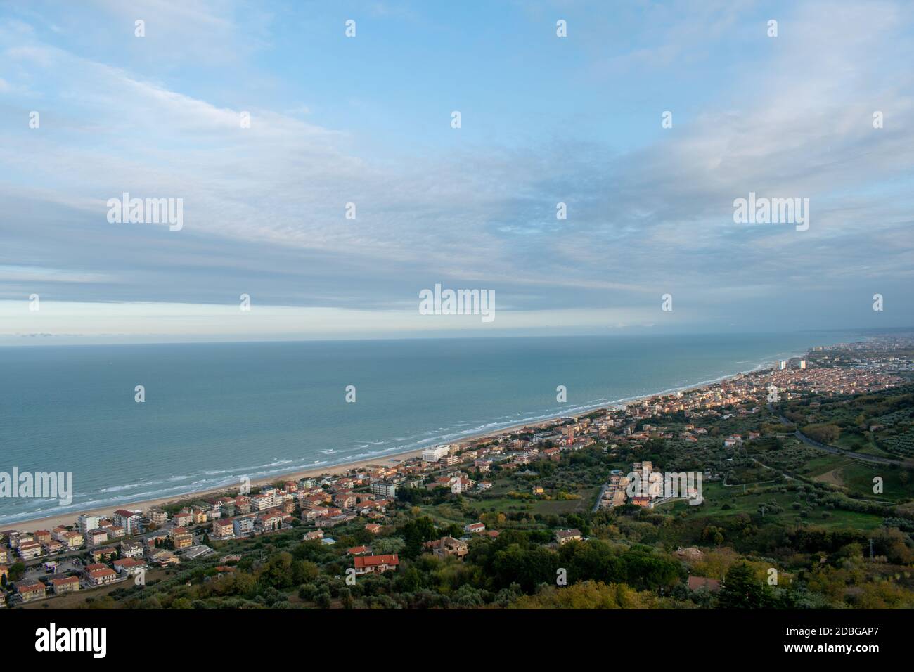 Wide angle shot of city against beach, sea and sky with horizon and mountains Stock Photo