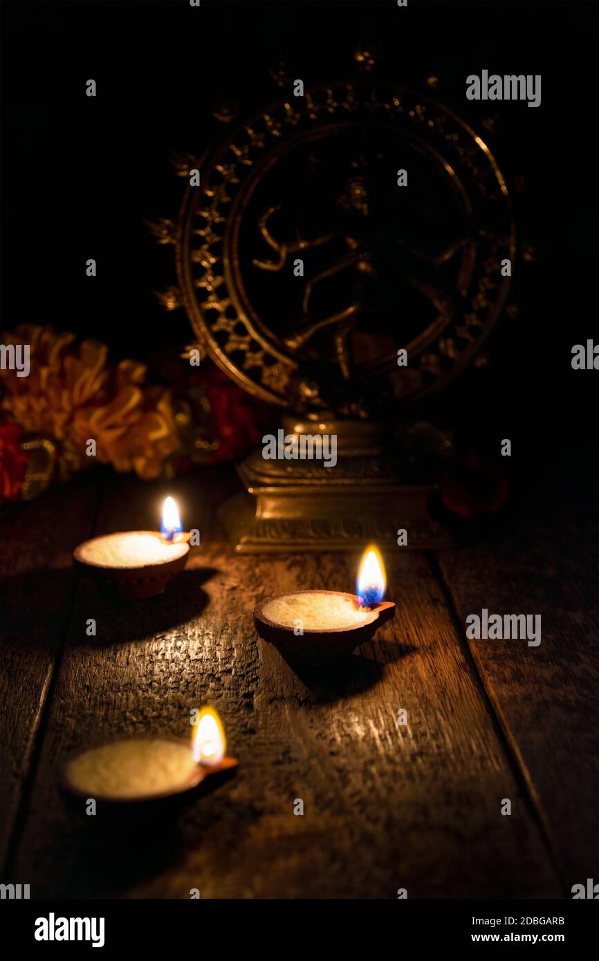 Diwali lights oil candles with Shiva Nataraja in the background for