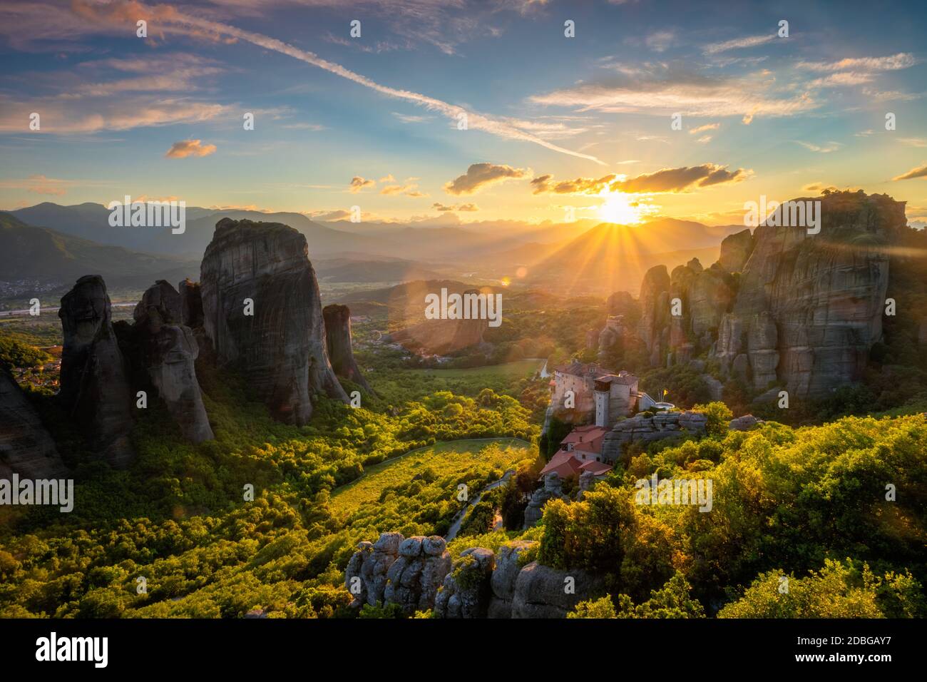 Sunset over monastery of Rousanou and Monastery of St. Nicholas Anapavsa in famous greek tourist destination Meteora in Greece on sunset with sun rays Stock Photo