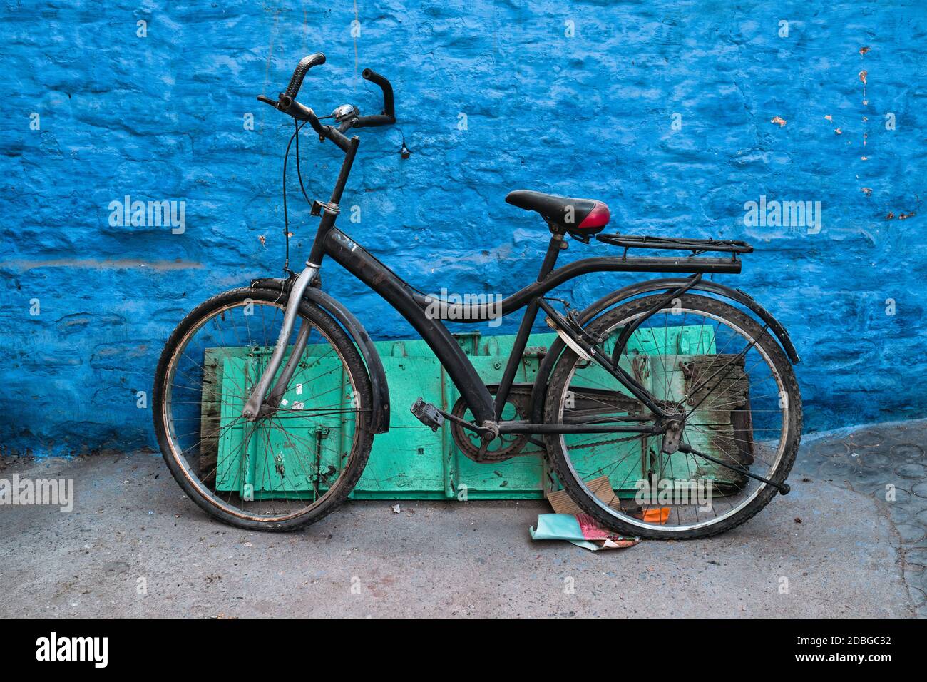 Old bicycle at the wall of blue house in streets of of Jodhpur, also known as Blue City due to the vivid blue-painted Brahmin houses, Jodhpur, Rajasth Stock Photo