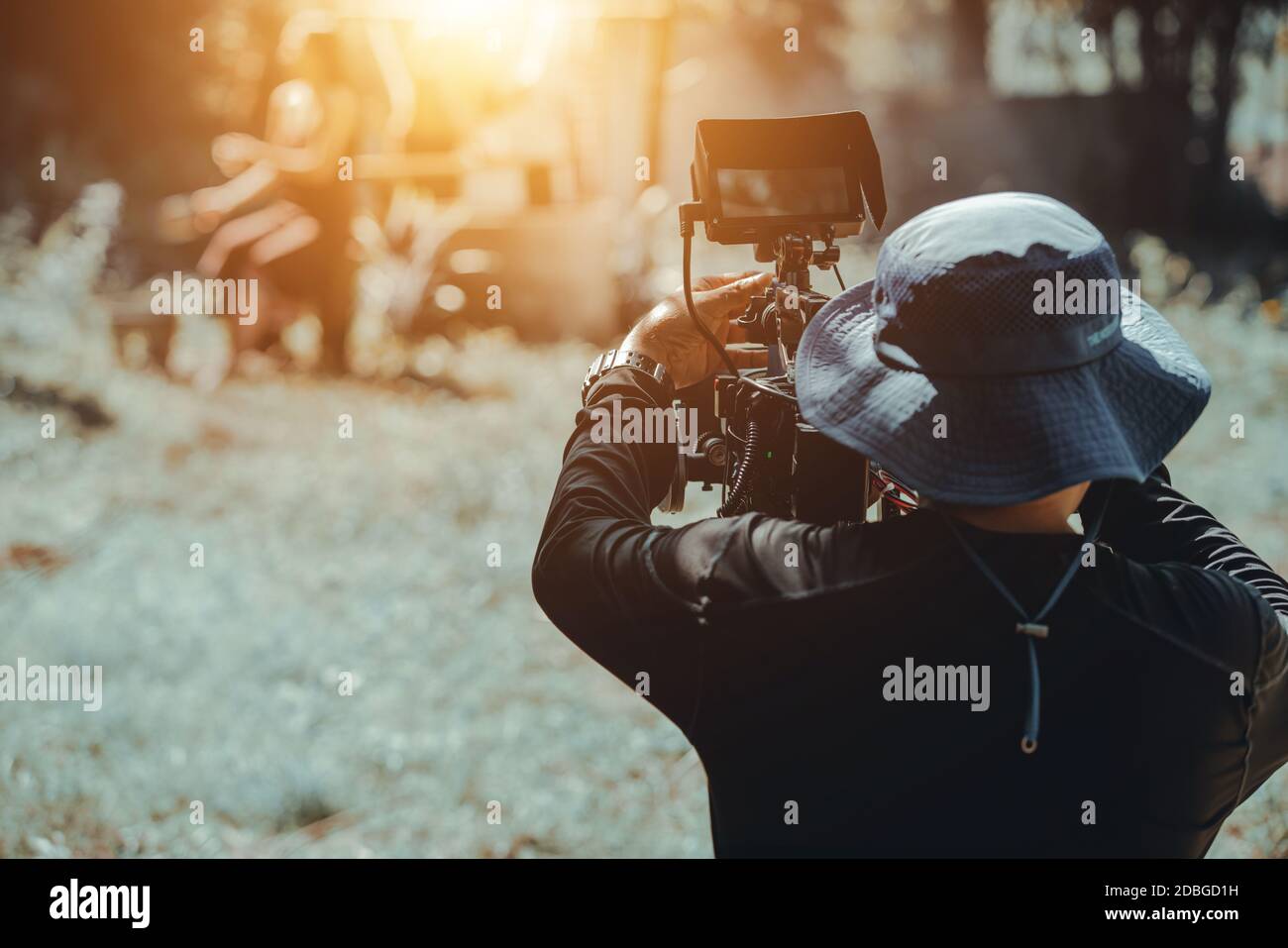 Behind cameraman operating camera shooting movie Stock Photo