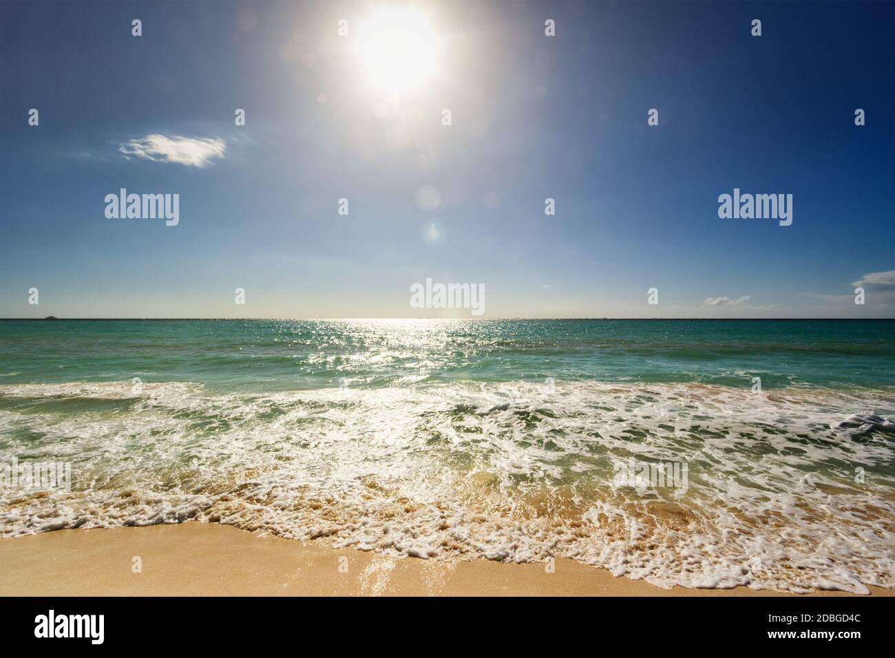 Beautiful beach and waves of Caribean Sea with blue sky and sun. With lens flare Stock Photo