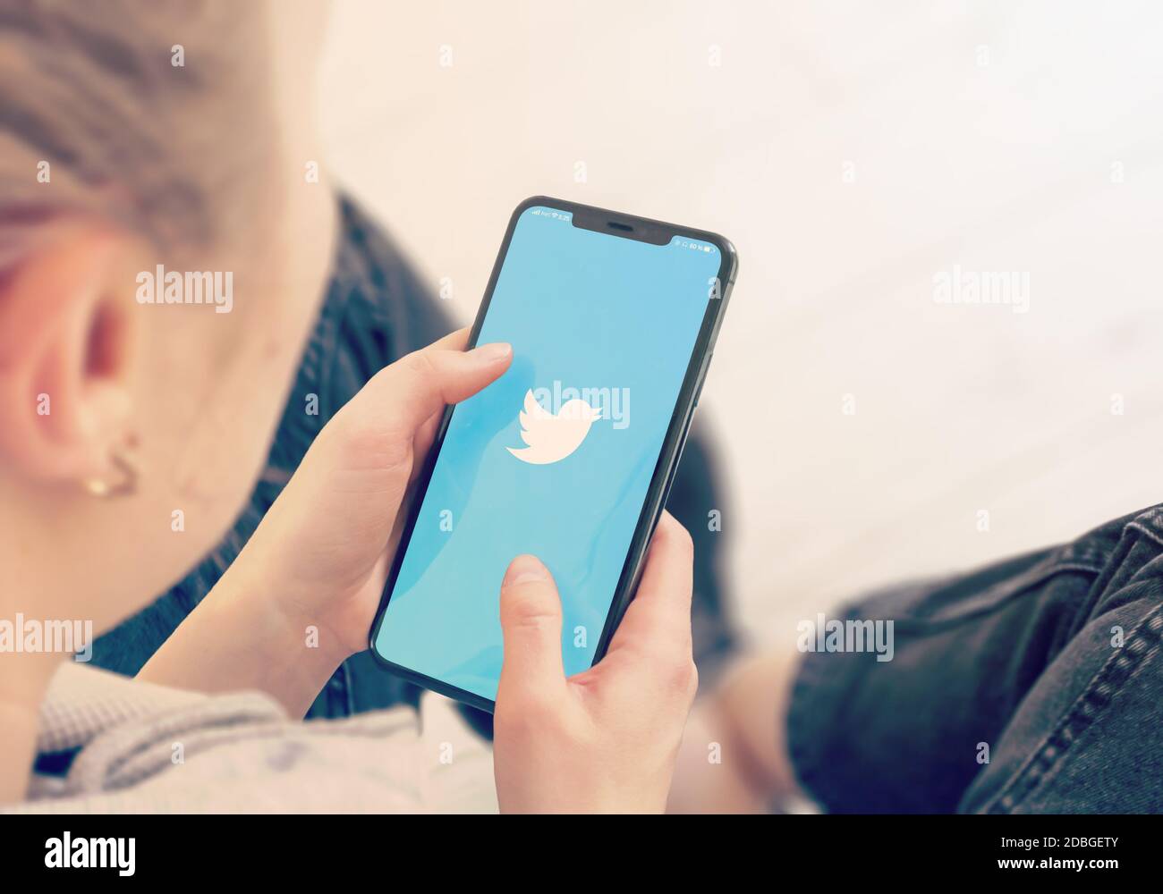 KYIV, UKRAINE-JANUARY, 2020: Twitter on Smart Phone Screen. Young Girl Pointing or Texting Cellphone During a Pandemic Self-Isolation and Coronavirus Stock Photo
