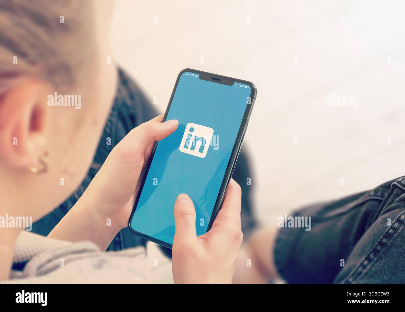 KYIV, UKRAINE-JANUARY, 2020: Linkedin on Mobile Phone Screen. Young Girl Pointing or Texting Smartphone During a Pandemic Self-Isolation and Coronavir Stock Photo