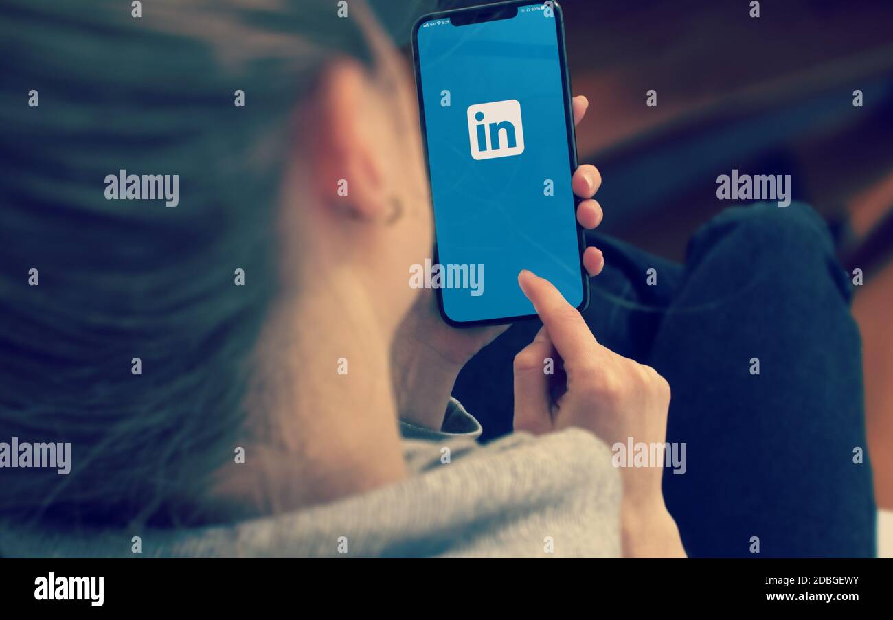 KYIV, UKRAINE-JANUARY, 2020: Linkedin on Mobile Phone Screen. Young Girl Pointing or Texting Linkedin on Smartphone. Stock Photo