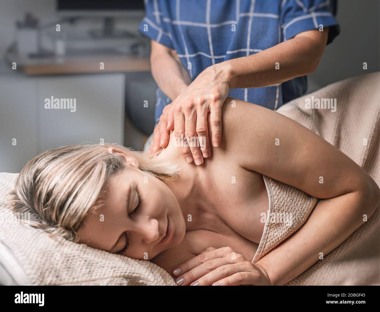 A young woman receiving massage, lay on massage bed Stock Photo