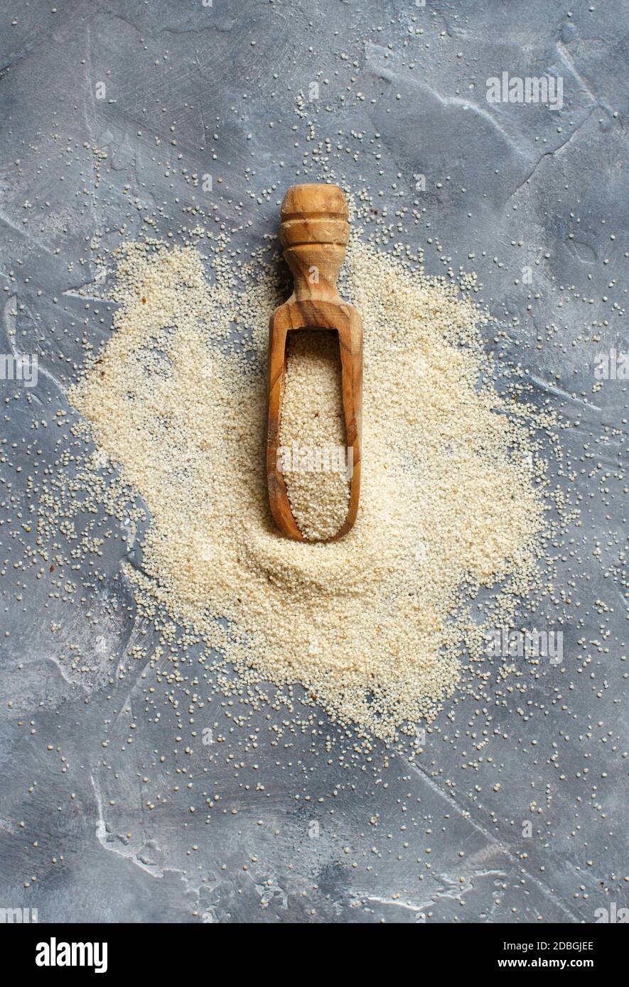 Raw uncooked fonio seeds with a spoon on grey background top view Stock Photo