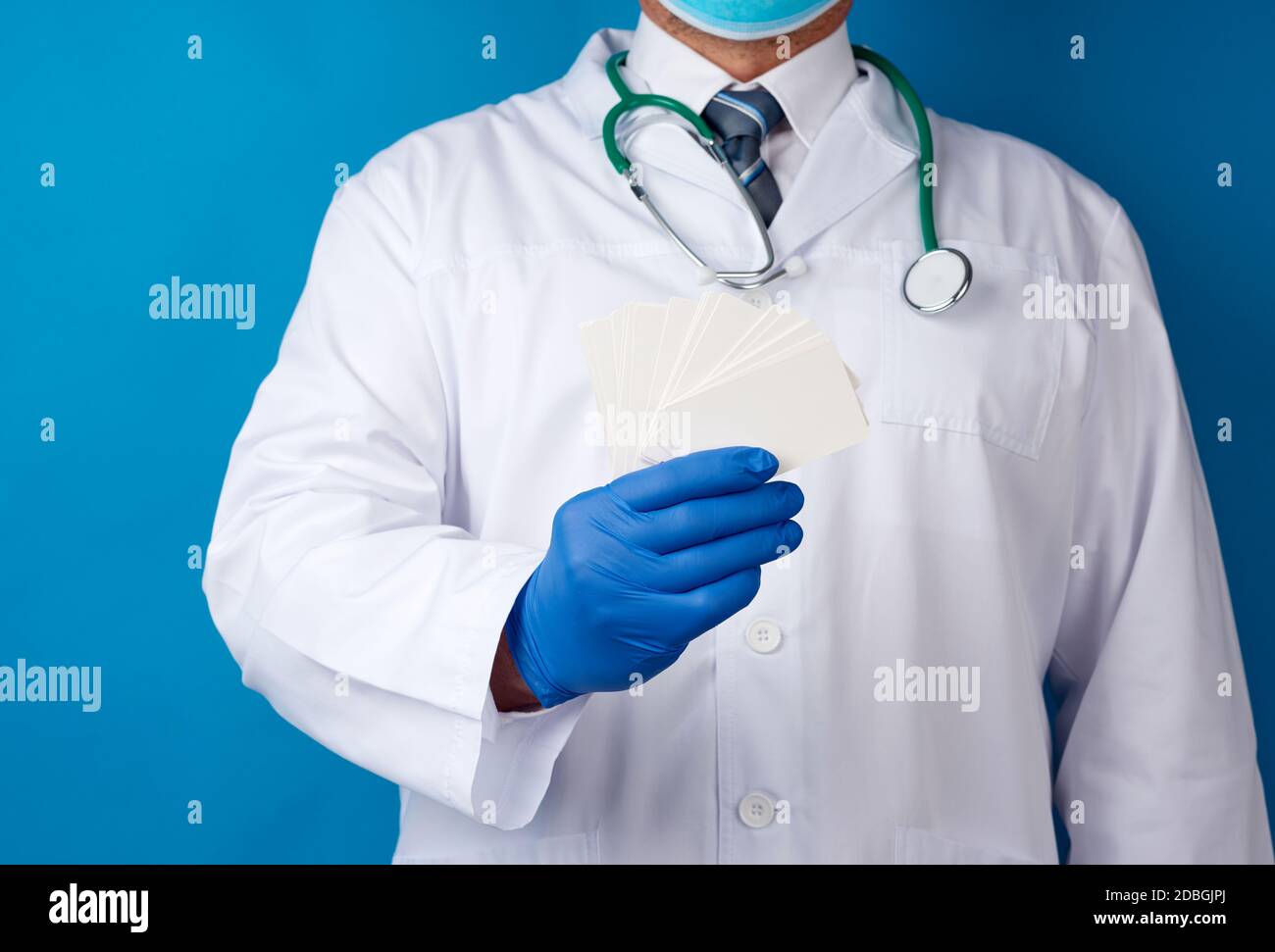 doctor therapist is dressed in a white robe uniform and blue sterile ...