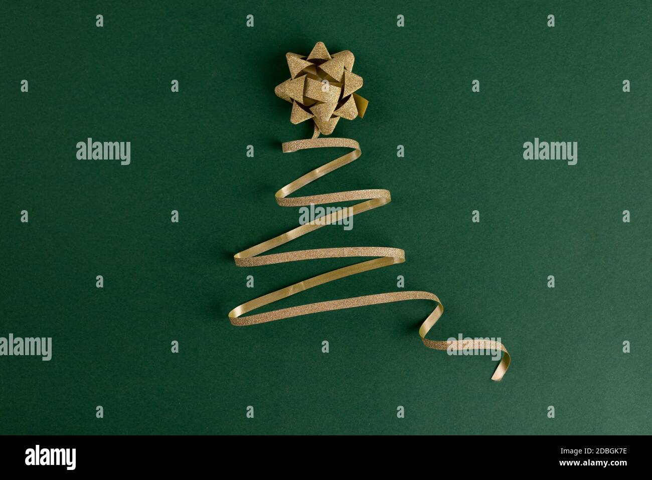 Christmas tree made from gold sparkling ribbon on a bright green ...
