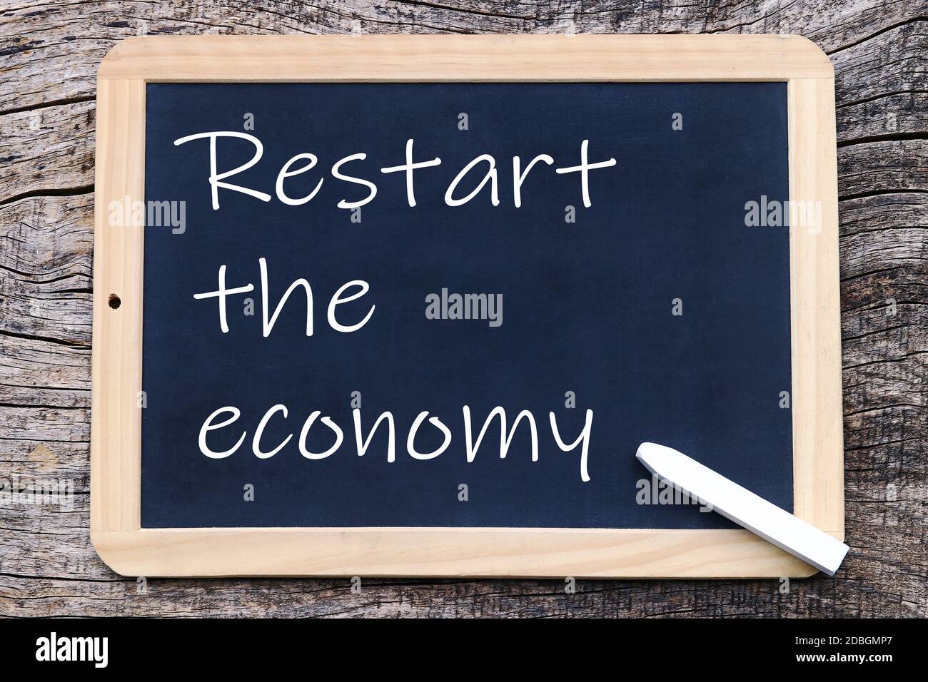Blackboard with the writing in English: Boosting the economy again! Stock Photo