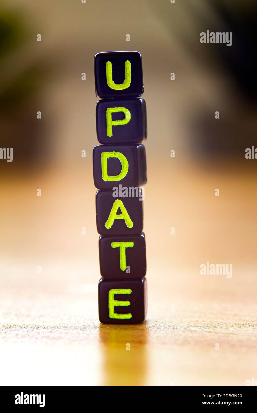 Update, vertical text in black cubes on a wooden table Stock Photo