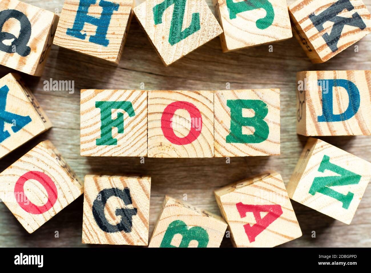 Alphabet letter block in word FOB (Abbreviation of Free on Board) with another on wood