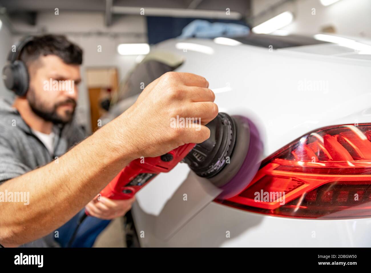 polishing the car body with a manual automatic grinder with wax and