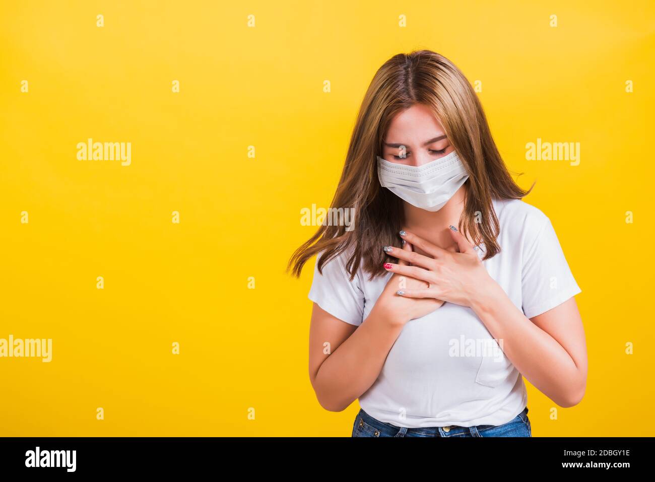 Asian portrait beautiful cute young woman standing wear t-shirt cough in mask protection from COVID virus epidemic or air pollution isolated, studio s Stock Photo