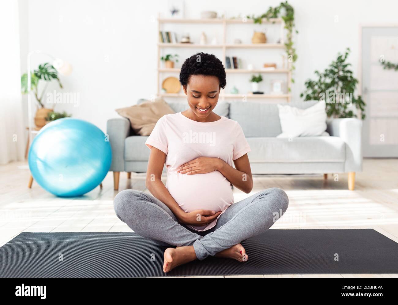 Sports and pregnancy concept. Lovely black expectant woman hugging her