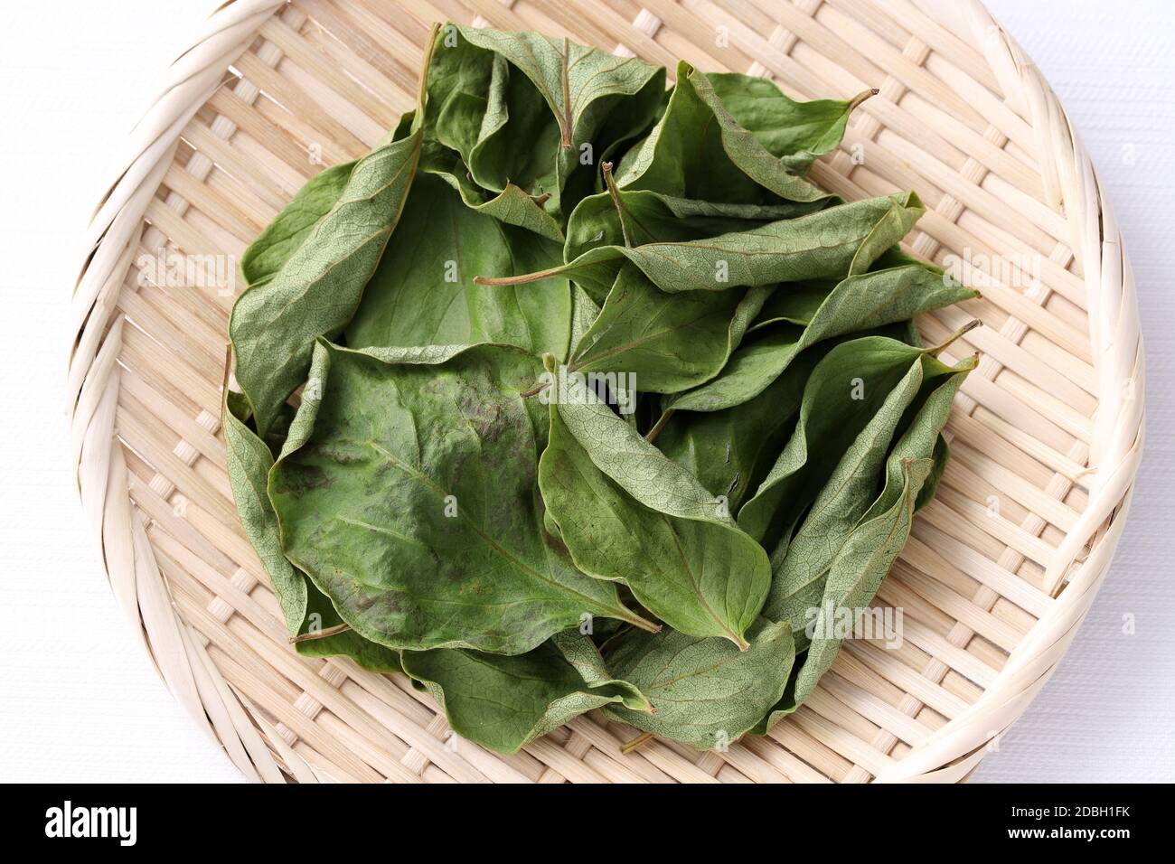 dried persimmon leaves, herbal medicine in a bamboo basket Stock Photo