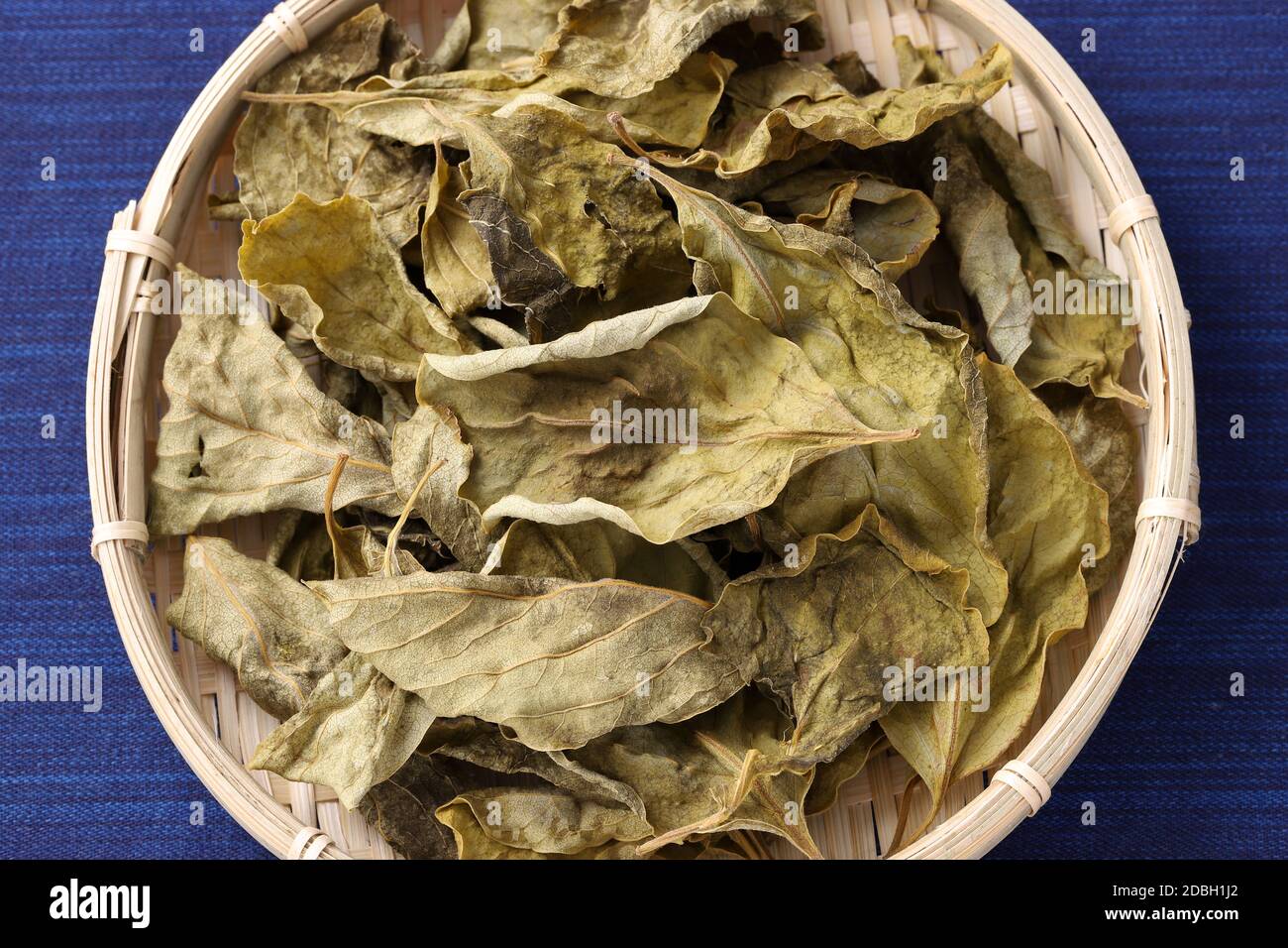 dried persimmon leaves, herbal medicine in a bamboo basket Stock Photo