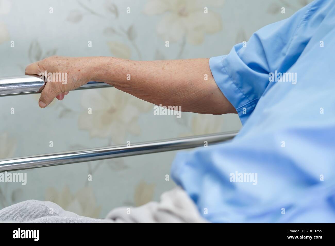 Asian senior or elderly old woman patient lie down handle the rail bed with hope on a bed in the hospital. Stock Photo