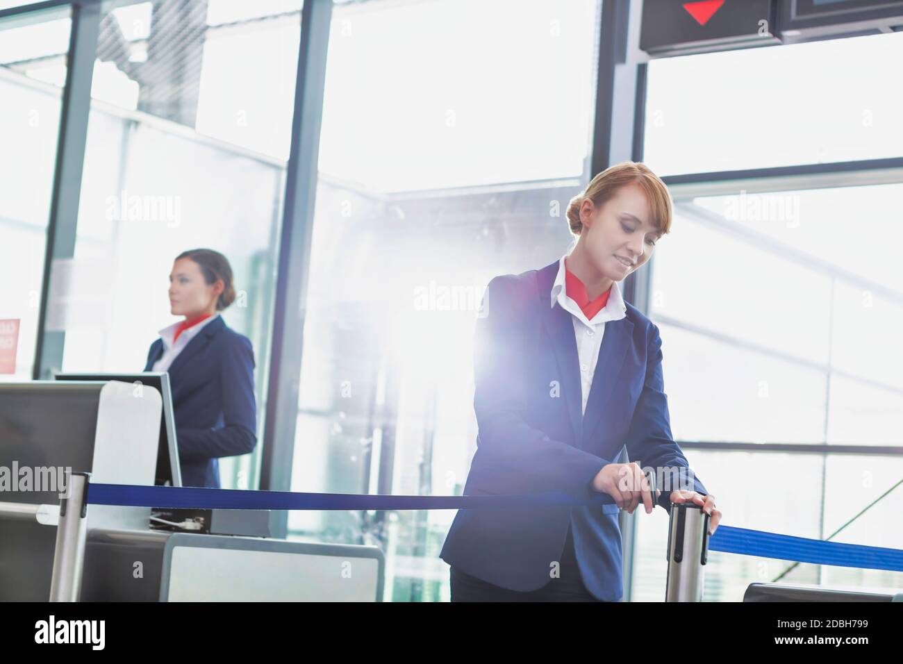 Portrait of young attractive passenger service agent opening the gate for boarding in airport Stock Photo