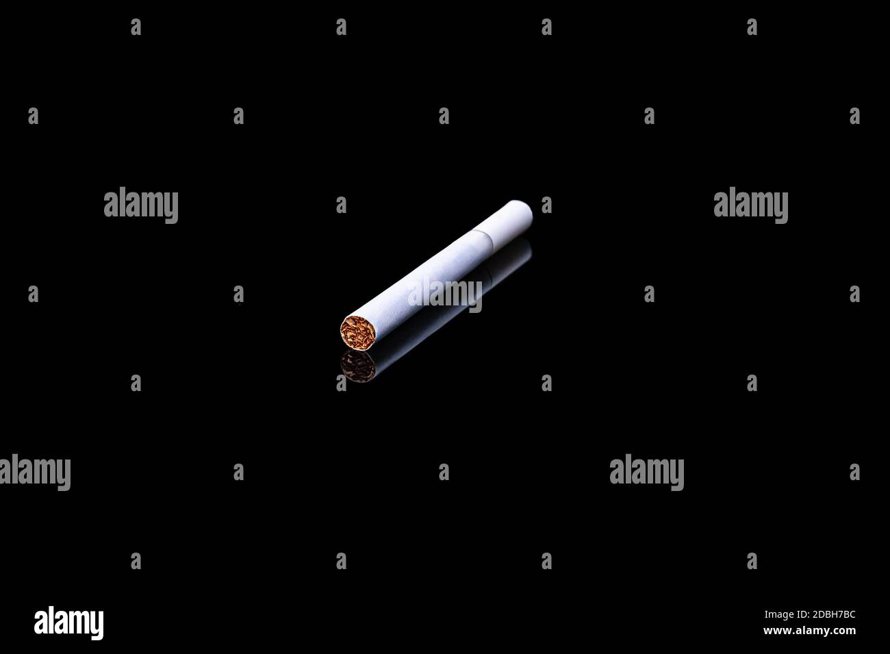 white filter cigarette on isolated black background with reflection