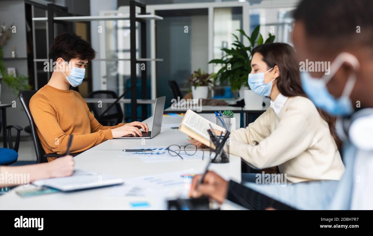 International people wearing medical masks sitting at coworking Stock ...