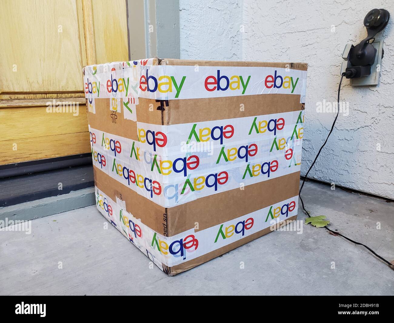 Photograph of a large cardboard shipping box secured with packing tape featuring the eBay logo on a doorstep in San Ramon, California, USA, November 8, 2020. () Stock Photo