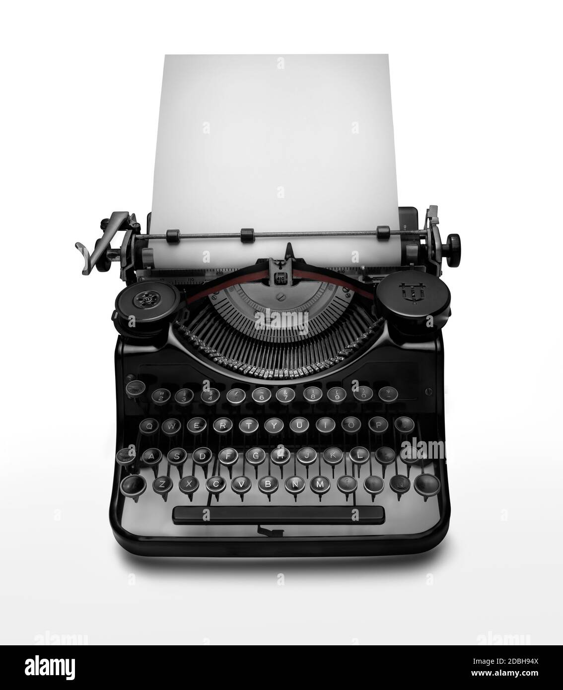 Vintage typewriter aginst white background. Low key edition of an ancient typewriter to give prominence to the space for text at the white page. Clipp Stock Photo
