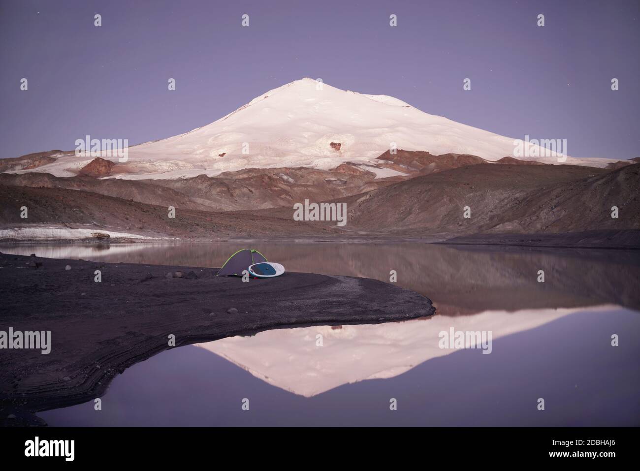 Camping on mountain lake Birdzhaly, Mount Elbrus on background. Caucasus, Russia. Stock Photo